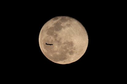 Un avión de pasajeros vuela delante de la luna en Cali, Colombia.