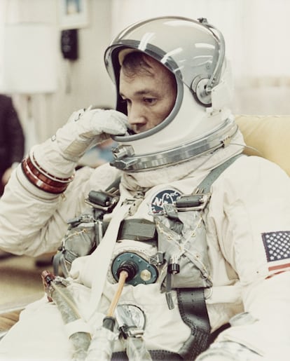 El piloto Michael Collins se ajusta el casco de su traje espacial en la sala de preparación de Cabo Kennedy, en Florida, antes de la misión Gemini 10 de la NASA, en julio de 1966.