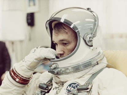 El piloto Michael Collins se ajusta el casco de su traje espacial en la sala de preparación de Cabo Kennedy, en Florida, antes de la misión Gemini 10 de la NASA, en julio de 1966.