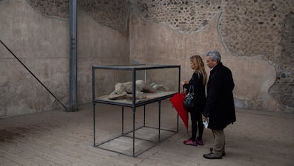 Visitors viewing the cast of a victim of the eruption in Pompeii.