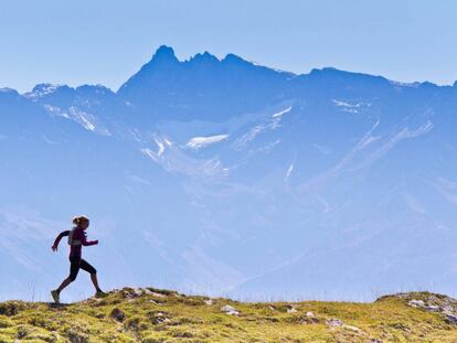 Una mujer corre con las montañas de fondo en el parque natural de Chartreuse, en Francia.