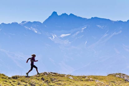 Una mujer corre con las montañas de fondo en el parque natural de Chartreuse, en Francia.