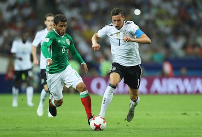 Jonathan Dos Santos (izquierda) de México y Julian Draxler luchan por hacerse con el balón.