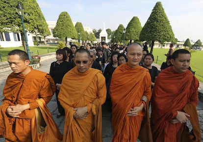 Monjes budistas y tailandeses vestidos de luto hacen cola para participar en una ceremonia de baño ritual en memoria del rey Bhumibol Adulyadej en el pabellón Sahathai Samakom dentro del Gran Palacio, en Bangkok (Tailandia).