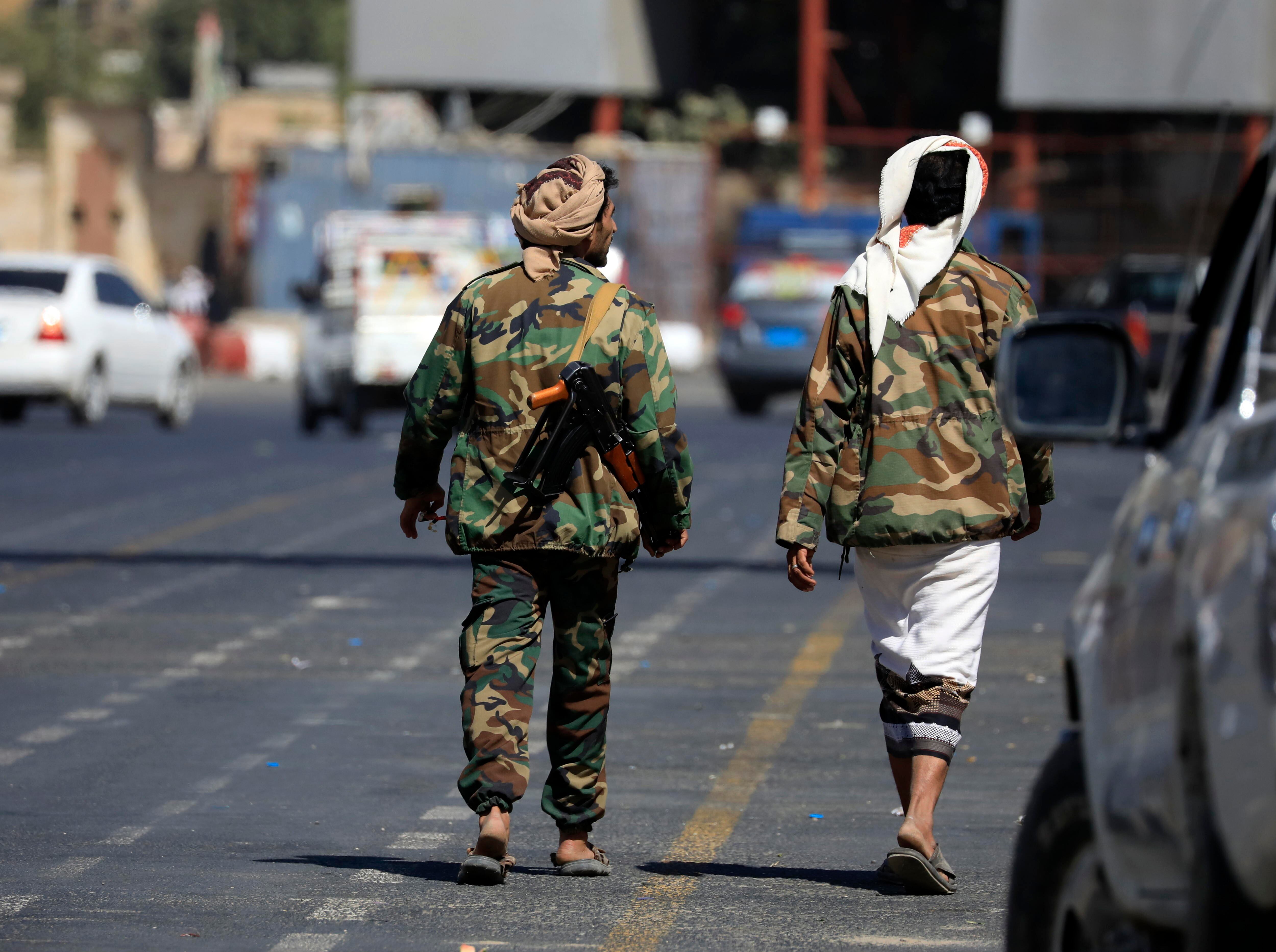 Dos luchadores de la milicia Huthi caminando por Saná, capital de Yemen, este martes. 