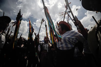 Manifestantes indígenas levantan sus bastones de mando en apoyo al Gobierno.