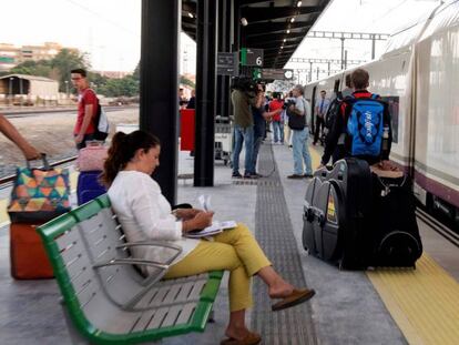 Varios pasajeros junto al nuevo AVE entre Granada y Madrid. 