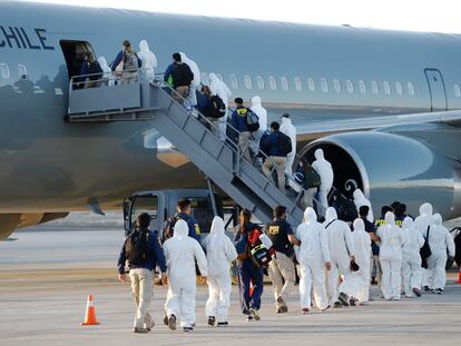 Migrantes venezolanos y colombianos son deportados vestidos con equipo de protección contra la covid-19, en el aeropuerto de Iquique, Chile, este miércoles.