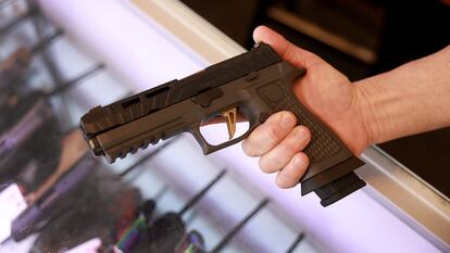 Un hombre sostiene una pistola en una tienda en Florida, en enero de 2023.