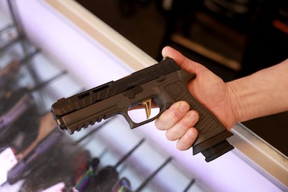Un hombre sostiene una pistola en una tienda en Florida, en enero de 2023.