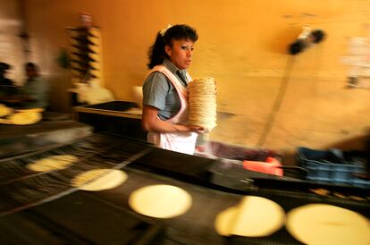 Una trabajadora recoge tortillas recién horneadas en una tortillería de Ciudad de México.