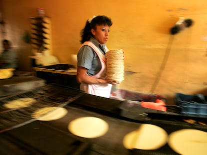 Una trabajadora recoge tortillas recién horneadas en una tortillería de Ciudad de México.