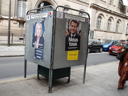 Una mujer pasa junto a carteles electorales del presidente Emmanuel Macron y de la líder de ultraderecha Marine Le Pen, en París, el 29 de marzo.