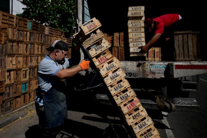 Dario Gomez and Darwin Perez load crates on a truck as they go to and from the main market to load up with produce to sell in Buenos Aires.
