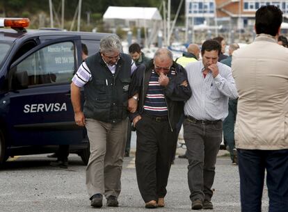 En la imagen, familiares y amigos de los fallecidos mientras esperaban sus cadáveres en el puerto de A Coruña.