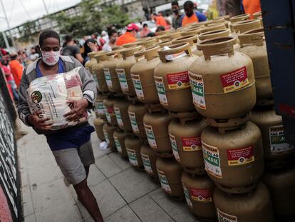 Homem carrega um pacote de alimentos que foi doado por um grupo de pessoas em uma campanha promovida por uma federação de trabalhadores no Rio de Janeiro, que vendeu gás pela metade do preço.