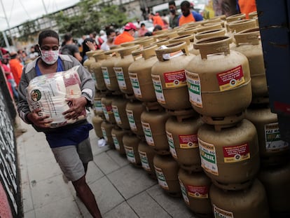 Un hombre lleva uno de los paquetes con alimentos que fueron entregados a un grupo de personas que compró gas a mitad de precio durante una campaña en 2021. La inflación ha disminuido el poder adquisitivo en Brasil.