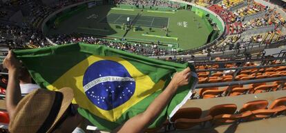 Aficionado con la bandera de Brasil en un partido de tenis de los Juegos Olímpicos.