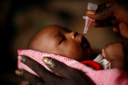 Un bebé es sostenido por su madre mientras recibe la vacuna oral de la polio en Rubkona (Sudán del Sur), en 2011.