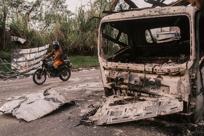 Un motociclista pasa junto a los restos de un vehículo que fue detonado con explosivos en la vía Panamericana, en el Cauca, el 29 de abril de 2026.