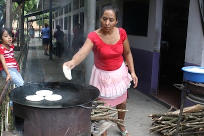 Mujer cocina tortillas con leña en El Salvador.