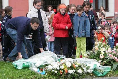 Profesores y compañeros del colegio donde estudiaban los dos fallecidos colocan ramos de flores en el lugar del accidente.