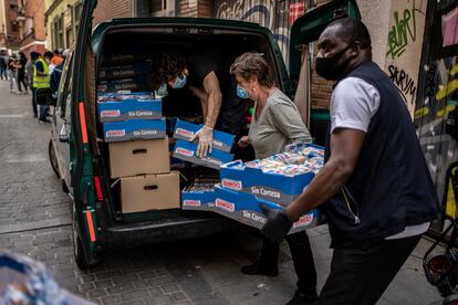 Miembros del Banco de Alimentos de Lavapiés dando comida a voluntarios de la Asociación de Inmigrantes Senegaleses en España.