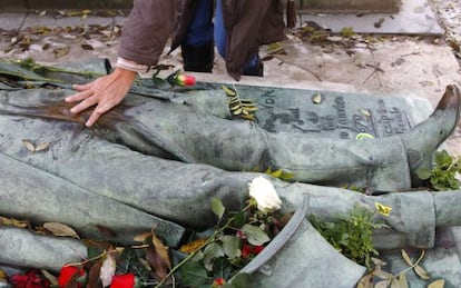 Un visitante frotando la escultura de Victor Noir en el cementerio Père-Lachaise, en París.