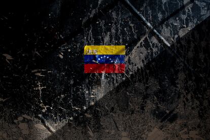 Una pegatina de la bandera de Venezuela sobre una puerta con los rastros de lodo después del desbordamiento del río.