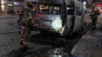 Un grupo de bomberos después de apagar un vehículo incendiado en Tijuana, Baja California (México), el 12 de agosto.