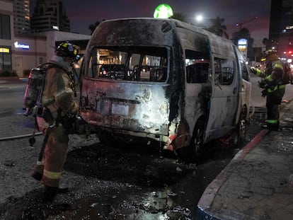 Un grupo de bomberos después de apagar un vehículo incendiado en Tijuana, Baja California (México), el 12 de agosto.