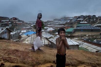 Dos niños sonríen mientras llueve en el campo de refugiados de Cox Baazar (Bangladesh), el 25 de junio de 2018.