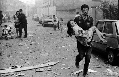 Un agente de la Guardia Civil ensangrentado lleva en brazos a una niña herida en el atentado contra la Casa Cuartel de Vic, en 1991.