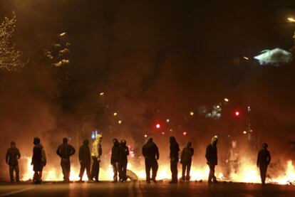 Varios manifestantes bloquean con una barricada una calle de Santiago.