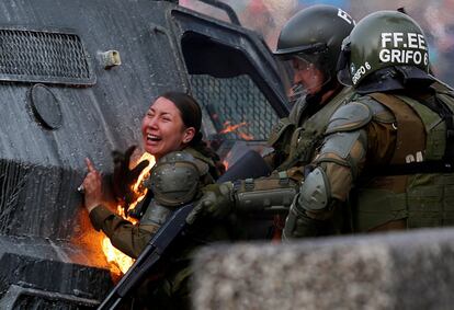 Una agente de la policía antidisturbios en llamas durante las protestas contra la política económica del Gobierno conservador en Santiago de Chile, este lunes 4 de noviembre.