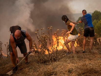 Vecinos colaboran en las labores de extinción en un incendio forestal, a 17 de julio de 2022, visto desde Sant Fruitós del Bages, Barcelona.