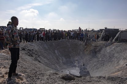 Palestinos inspeccionan un crter causado por el bombardeo israel en un campamento de desplazados en Khan Younis.