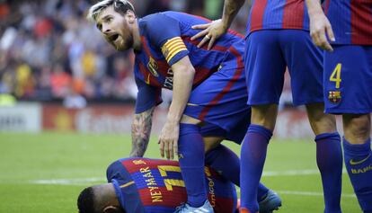 Messi junto a Neymar, tras recibir el impacto de una botella en Mestalla. 