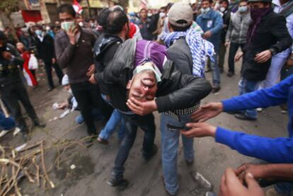 Manifestantes trasladan a un herido en choques con las fuerzas del orden en El Cairo.