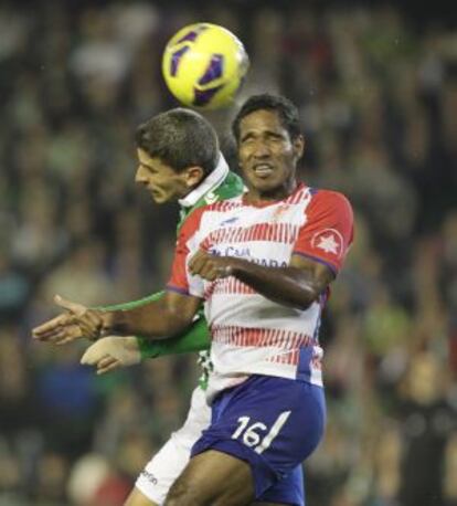 Brayan Angulo salta con Salva Sevilla durante un partido del Granada ante el Betis