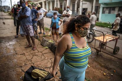 Yuliet Colón carrega seu carrinho de supermercado enquanto caminha para casa após uma visita ao mercado agrícola em Havana, Cuba, em 2 de abril.