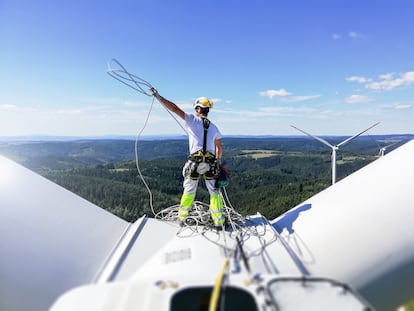 Un técnico realiza labores de mantenimiento en una turbina eólica.