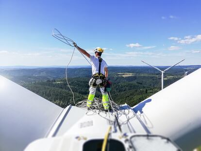Un técnico realiza labores de mantenimiento en una turbina eólica.