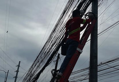 A lineman works on an electric post in Makati city, Metro Manila, Philippines, 24 July 2023.