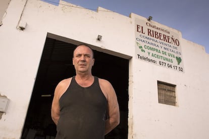 Juan Antonio Merino posa en la puerta de su chatarrería, en Almendralejo, donde también compra el rebusco de uva y aceituna. A principios de octubre, antes de que la Junta de Extremadura paralizara esta práctica, este hombre pagaba a siete céntimos el kilo de uva y lo revendía a nueve, según asegura.