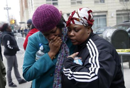 Alicia Thomas que vivía en uno de los edificios destruídos por la explosión, es consolada por una amiga.