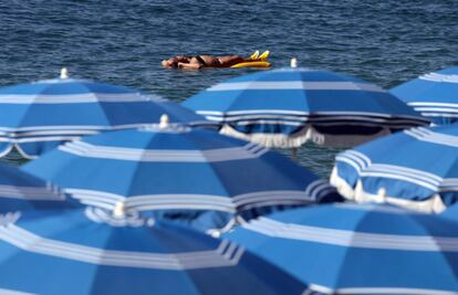 Una mujer disfruta del sol en las aguas de la playa de Niza (Francia).