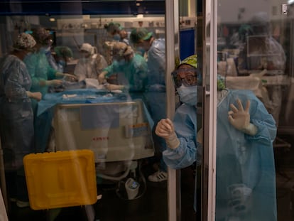 Doctors perform a tracheotomy on a Covid-19 patient in critical care in Barcelona's Del Mar Hospital.