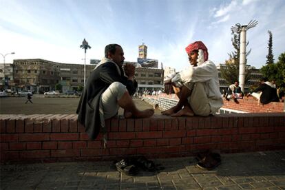 Dos hombres charlan sentados en la plaza Tahrir, en la Ciudad Antigua de Saná.