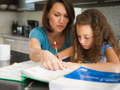 Una madre ayuda a su hija con sus estudios.